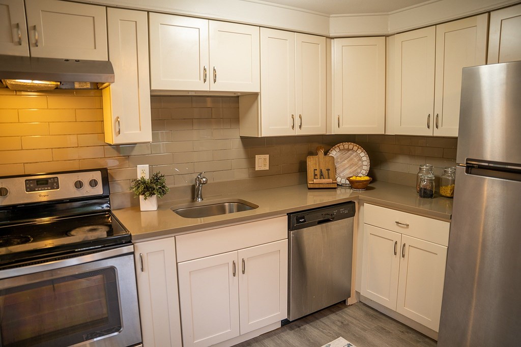A kitchen with white cabinets and stainless steel appliances.