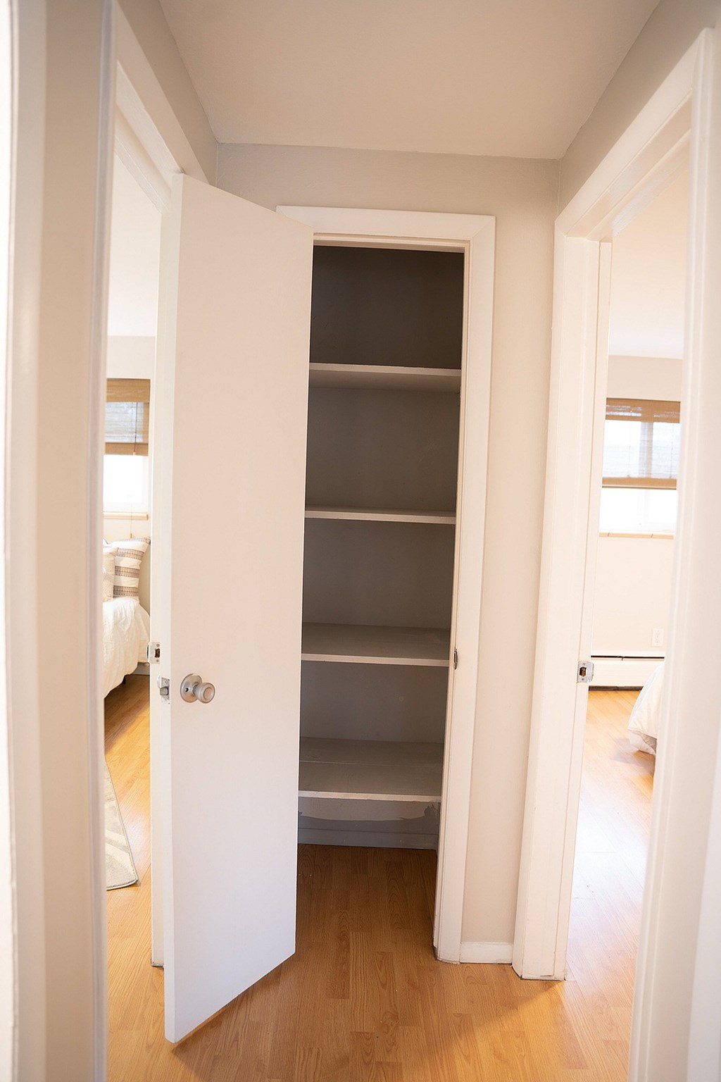 A white door is open to a room with a white wardrobe.