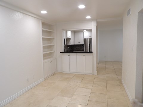 A kitchen with white cabinets and a black countertop.