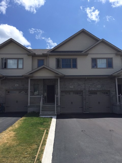A house with a grey roof and a white garage door.