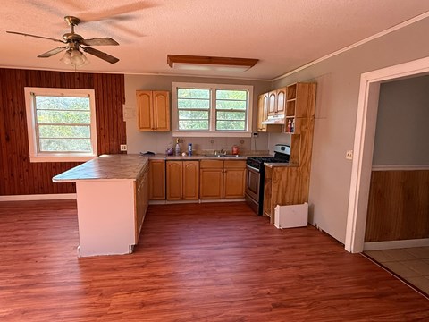 A kitchen with wooden cabinets and a white island.