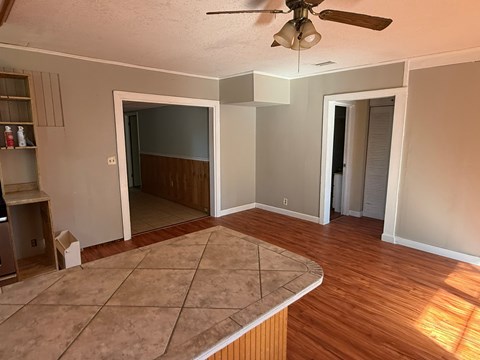 A room with a ceiling fan and a tile floor.