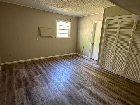 A room with wooden flooring and a window.