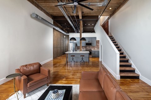 A living room with a brown leather couch and a black and white rug.
