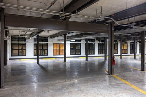 A large, empty warehouse with concrete floors and yellow safety lines.