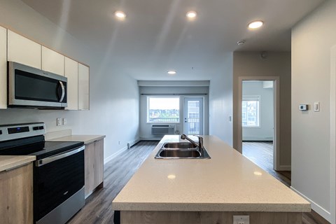 A kitchen with a stove top oven and microwave above a counter.