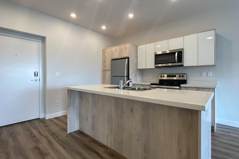 A kitchen with a white countertop and wooden cabinets.
