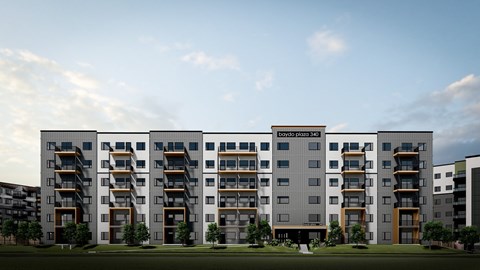 A modern apartment building with balconies and a green lawn in front.