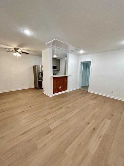 A room with wooden flooring and a ceiling fan.