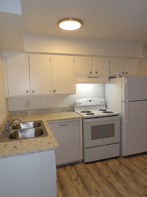 A kitchen with white appliances and cabinets.