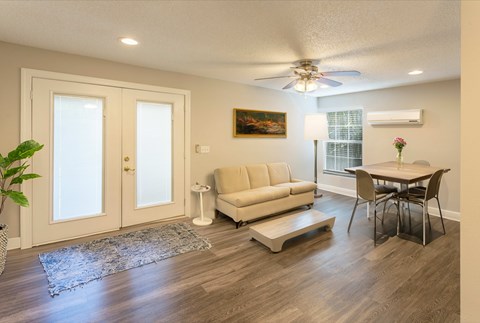A living room with a couch, chair, and a painting on the wall.