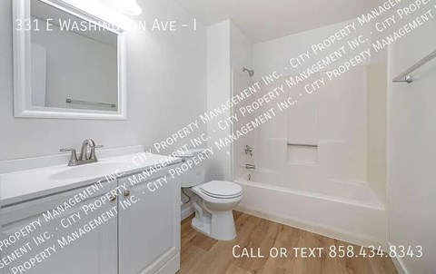A white bathroom with a toilet, sink, and bathtub.