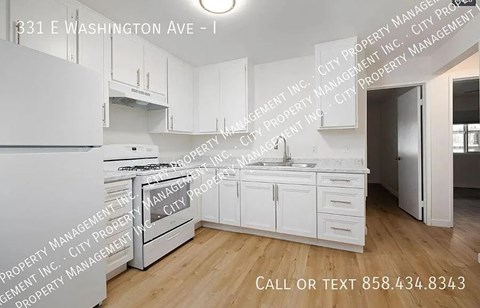A kitchen with white appliances and cabinets at 331 E Washington Ave.