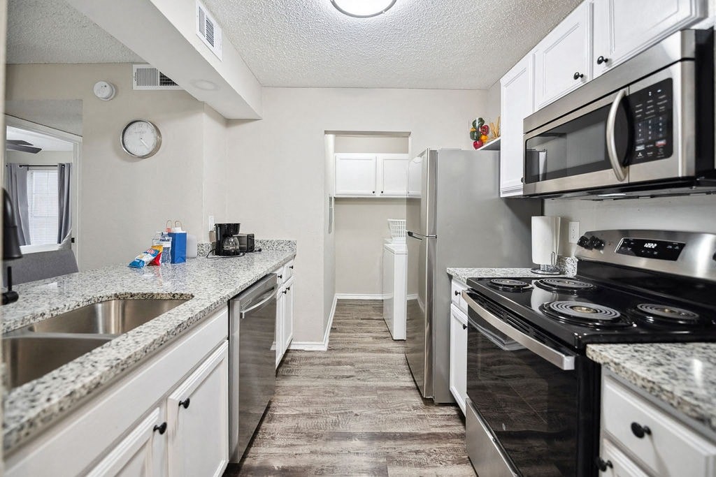 A kitchen with a stove top oven and a microwave above it.