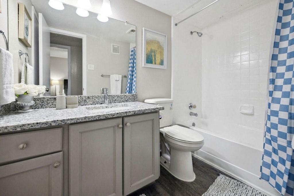 A bathroom with a checkered shower curtain.