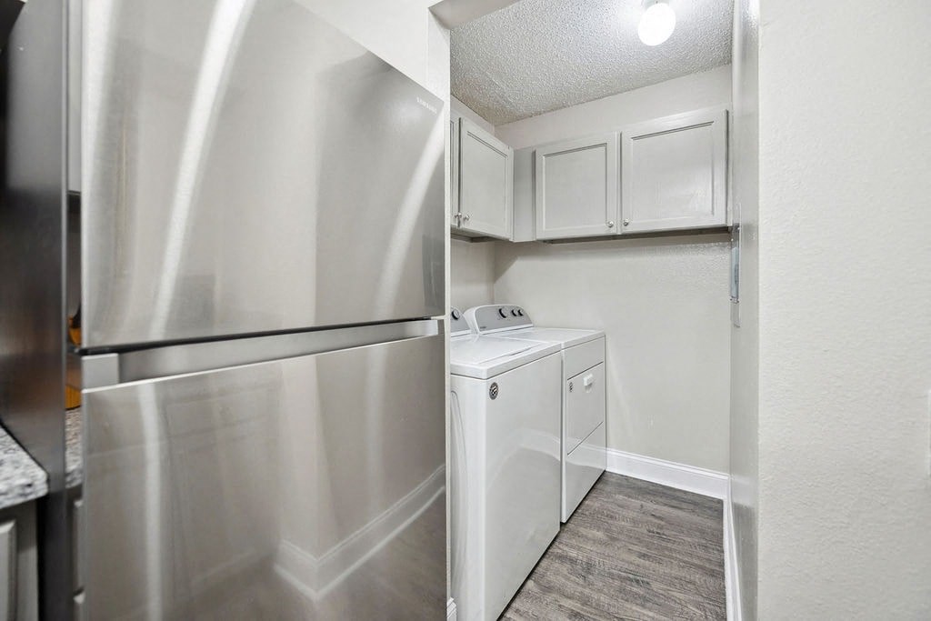 A small kitchen with a refrigerator and a washing machine.