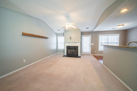 A living room with a fireplace and a ceiling fan.