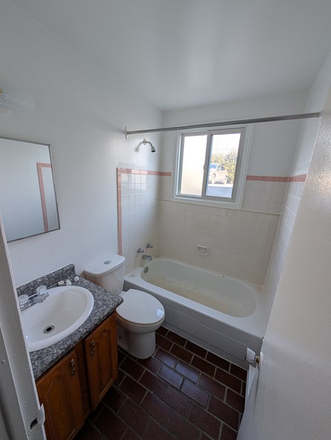 A bathroom with a toilet, sink, and bathtub.