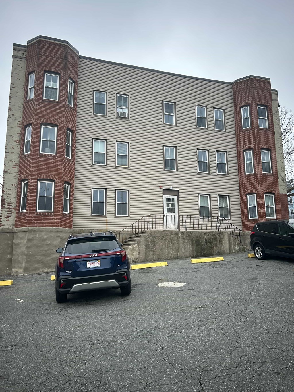 A black SUV is parked in a parking lot in front of a building.