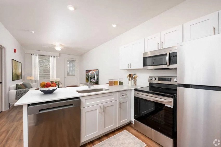 A modern kitchen with stainless steel appliances and white cabinetry.