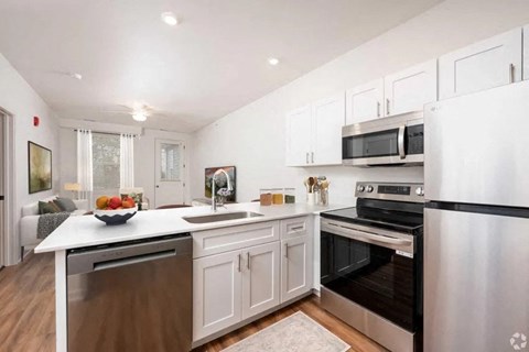 A modern kitchen with stainless steel appliances and white cabinetry.