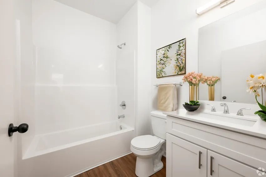 A white bathroom with a toilet, sink, and bathtub.