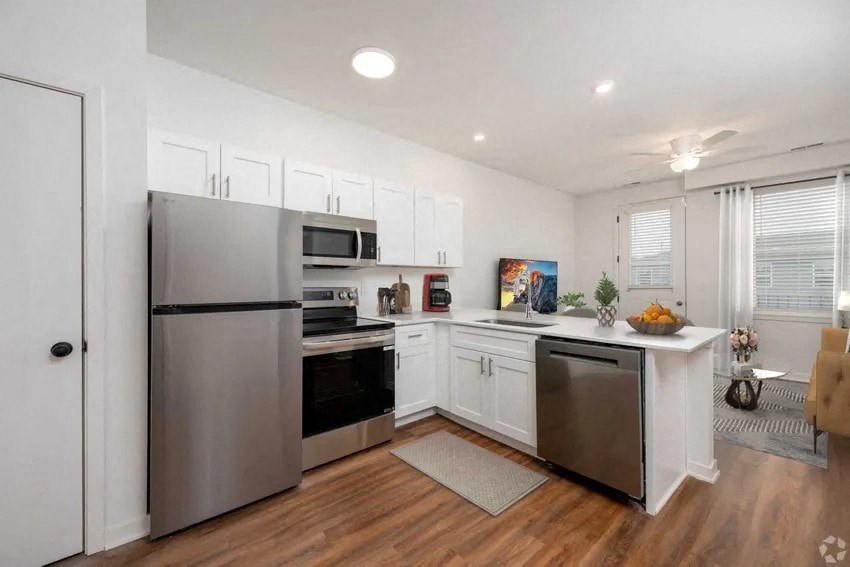A modern kitchen with stainless steel appliances and white cabinets.