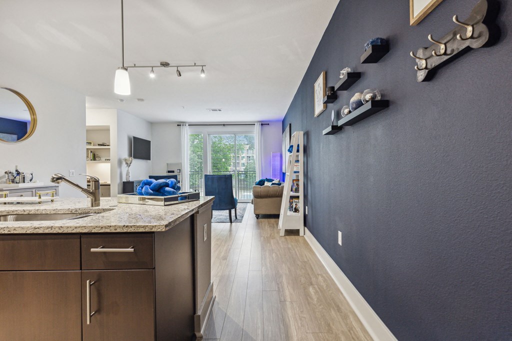 A modern kitchen with dark blue walls and wooden floors at Everra Midtown Park Apartments, Dallas, TX