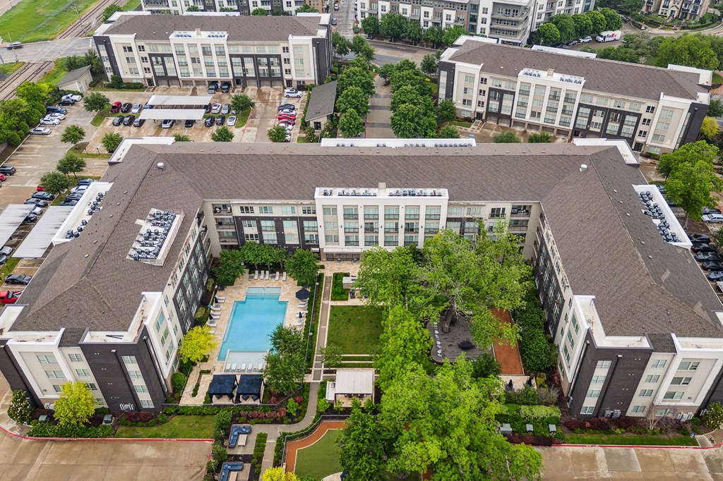 A large apartment complex with a pool in the middle at Everra Midtown Park Apartments, Dallas