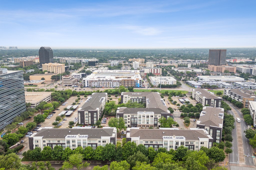 A cityscape with a mix of modern and older buildings, surrounded by greenery at Everra Midtown Park Apartments, Texas