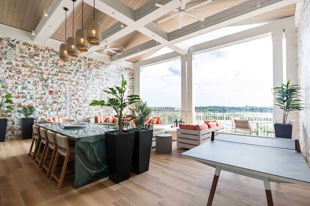 A dining area with a table set for six and a view of the water.