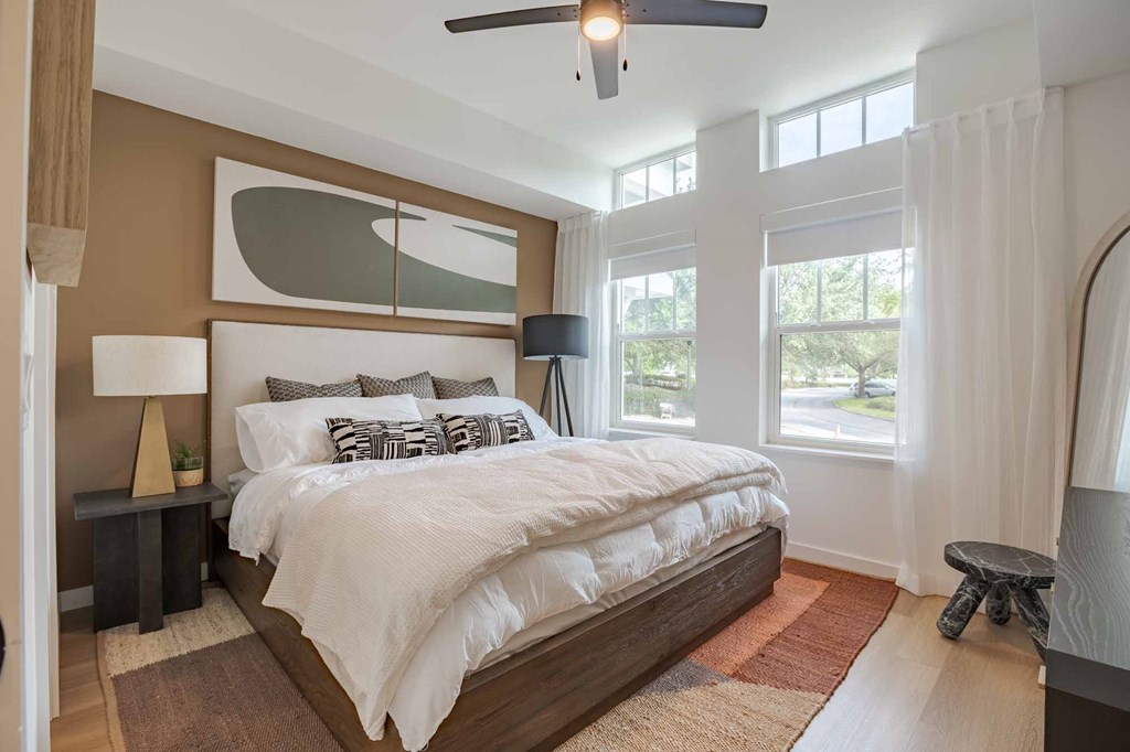 A bedroom with a large bed and a ceiling fan.