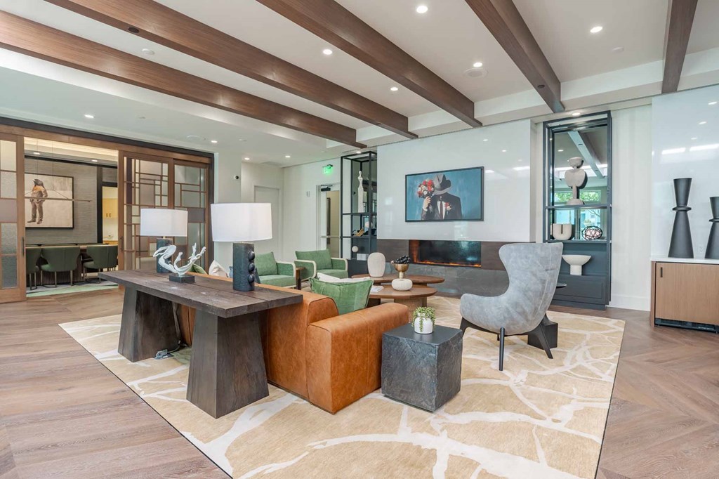 A modern living room with a wooden floor and a large rug.