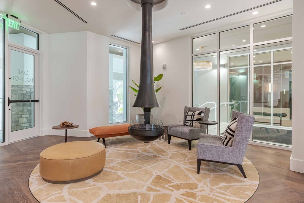 A living room with a large rug and a tall floor lamp.