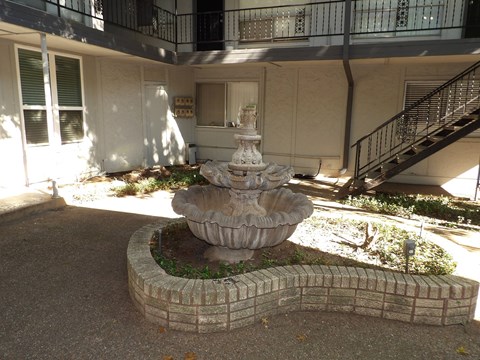 A stone fountain in the middle of a courtyard.