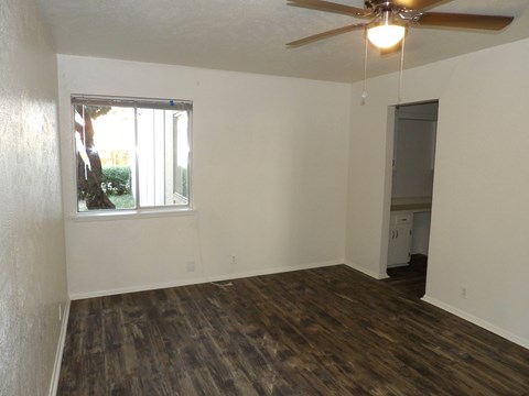 A room with a ceiling fan and a window.