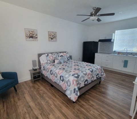 A bedroom with a bed, nightstand, and a ceiling fan.