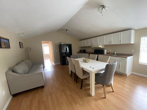A kitchen with a dining table and chairs.