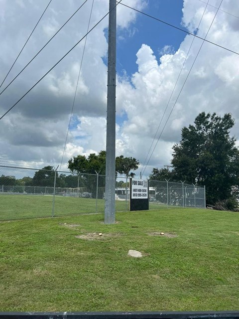 A sign in the middle of a grassy field reads "For Sale".