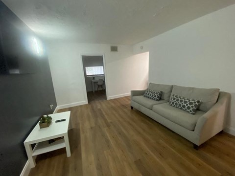 A living room with a grey couch and a white coffee table.