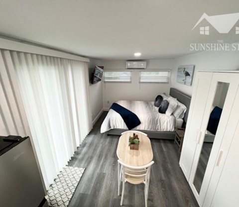 A small room with a bed, a table, and a chair.