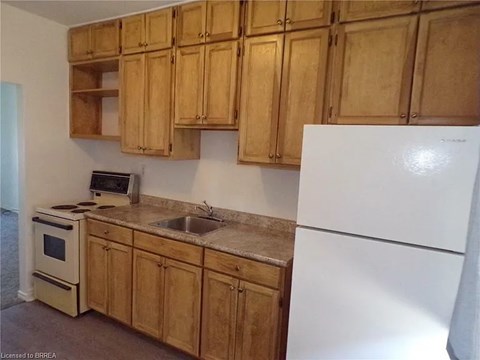 A kitchen with wooden cabinets and a white refrigerator.