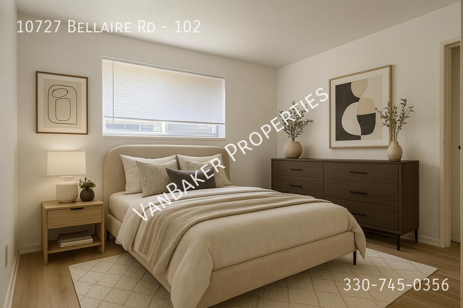 A bedroom with a bed, nightstand, and a painting on the wall.