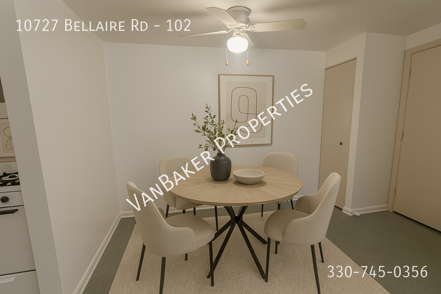 A dining room with a table and chairs and a phone number on the wall.