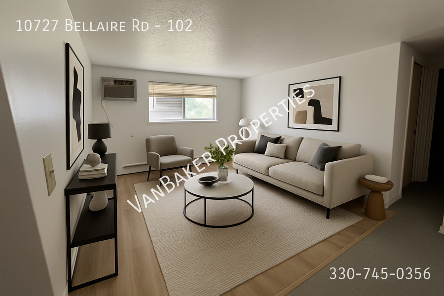 A living room with a sofa, a coffee table, and a painting on the wall.