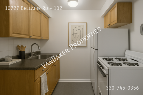 A kitchen with a white stove and wooden cabinets.
