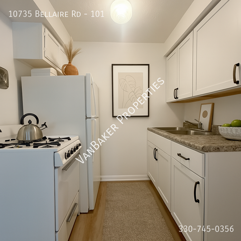 A kitchen with a white stove and white cabinets.