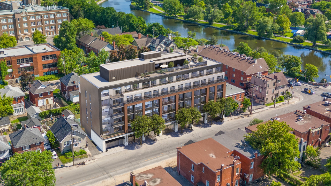 A large building sits in the middle of a street with a river in the background.
