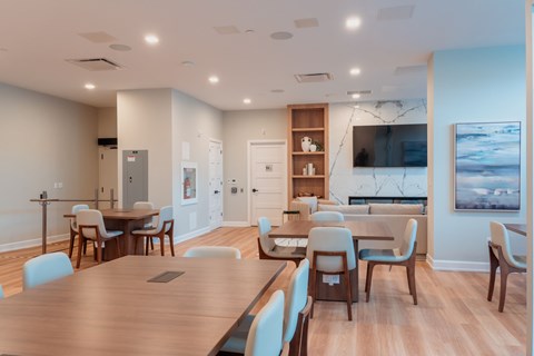 A modern dining room with a large wooden table and chairs.