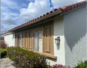 A white house with a brown door and windows.